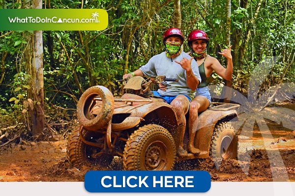 Pareja en una cuatrimoto en un lugar con lodo saludando