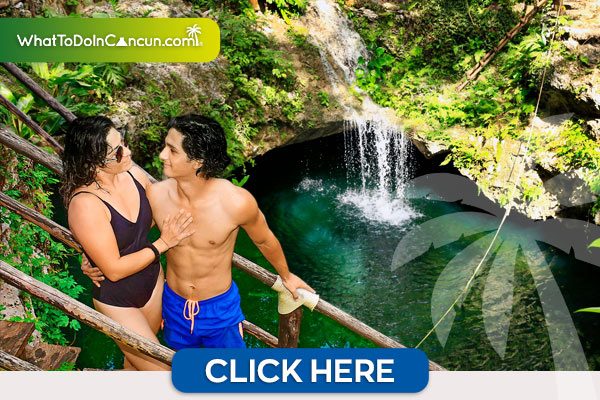 Pareja en un cenote con una cascada de fondo